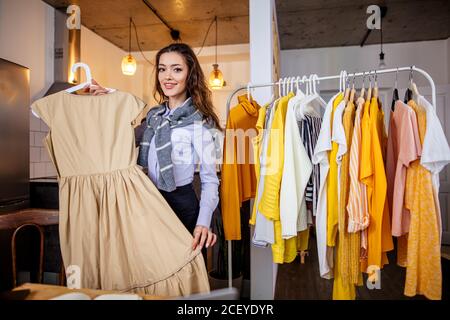 bella cute blogger caucasica donna confrontare e mostrare nuovi vestiti a macchina fotografica, si condivide con tutte le notizie nella sua vita con gli abbonati Foto Stock