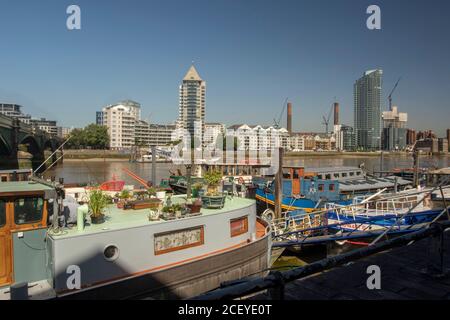 Houseboats si oppone all'architettura di gentrifificazione lungo il fiume Tamigi a Battersea, Greater London, England, United Kingdom, Europe Foto Stock