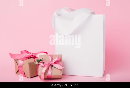 Fatevi un sacco di carta e confezioni regalo per San Valentino con un posto per il vostro testo. Foto mock up su sfondo rosa Foto Stock