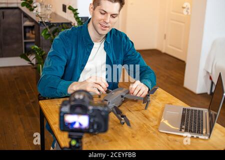 bel blogger uomo caucasico parlare di dispositivi moderni e tecnologie, sedersi di fronte alla fotocamera e presentare il suo acquisto, nuovo dispositivo. blogging, broa Foto Stock