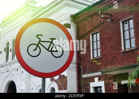 Cartello che proibisce il ciclismo sullo sfondo degli edifici urbani. Foto Stock