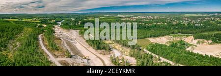 Panorama drone foto sulla costruzione di una nuova autostrada e ponte sul fiume Umea - molte macchine industriali pesanti lavorano insieme - dumper, bulldozer Foto Stock