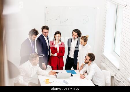 riunione di lavoro di un team di successo amichevole in sala riunioni, leader attivi ed entusiasti che hanno buoni risultati sul lavoro. isolato in business off leggero Foto Stock