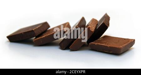 Cubetti di cioccolato isolati su sfondo bianco. Vista ravvicinata. Cioccolato belga dolce. Foto Stock