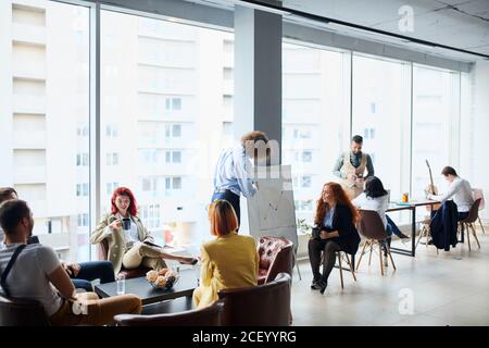 Uomo di affari riuscito e ambizioso fa la presentazione al commercio creativo il team si è riunito in ufficio Foto Stock