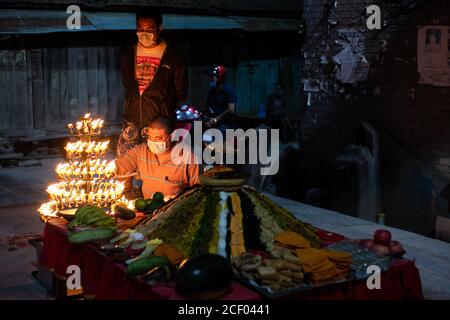 Kathmandu, Nepal. 10 settembre 2020. Un devoto indù nepalese che indossa una maschera facciale offre preghiere accanto al Samyabaji durante il festival Indra Jatra.Indra Jatra, il festival di Rein di Dio è celebrato con molto fanfare nella valle di Kathmandu. In questo festival di otto giorni, i carri della dea vivente Kumari e degli dei viventi Ganesh e Bhairab sono tirati in varie parti della città, ma a causa della pandemia di Covid-19 per la prima volta nella storia la lavorazione dei carri è stata annullata. Il pulu kisi e il lakhey erano adorati alle loro case. Credit: Prabin Ranabhat/SOPA Images/ZUMA Wire/Alamy Live News Foto Stock