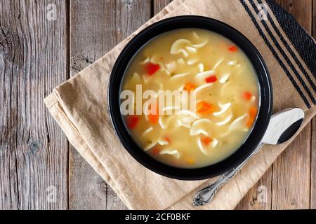 Tradizionale zuppa di noodle di pollo, sopra la scena su un rustico sfondo di legno Foto Stock