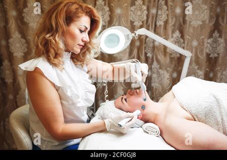 Donna distesa mentendo e con una terapia professionale anti-rughe Foto Stock