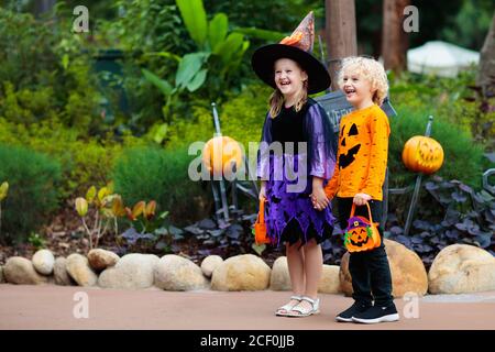 Bambino in costume di Halloween. I bambini trick o treat. Ragazzo e ragazza vestita come strega con cappello che tiene lanterna di zucca e secchio di caramelle. Celebr famiglia Foto Stock