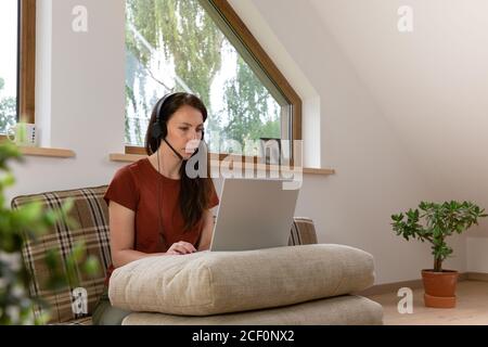 Donne che lavorano da casa durante una chiamata in conferenza. Scrivania con cuscini. Nuovo concetto normale Foto Stock