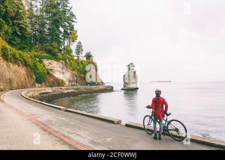 Ciclista di Vancouver donna in bicicletta su pista ciclabile intorno a Stanley Park, famosa attività turistica nella Columbia Britannica, Canada. Foto Stock