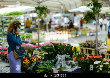 Cremona, Italia - Settembre 2020 Venditore di fiori e piante al mercato settimanale di strada. I giardinieri ed i clienti portano la maschera di faccia e mantengono la distanza- Foto Stock