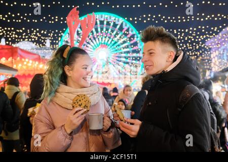 Ritratto di Natale invernale di felice adolescente ragazzo e ragazza a. mercato delle vacanze Foto Stock