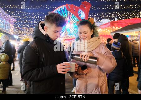 Ritratto di Natale invernale di felice adolescente ragazzo e ragazza a. mercato delle vacanze Foto Stock