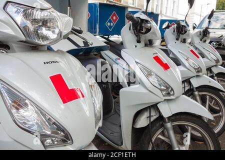 Una fila di scooters di consegna di Pizza fuori del ristorante di consegna di fast food di Domino, Londra, Regno Unito Foto Stock