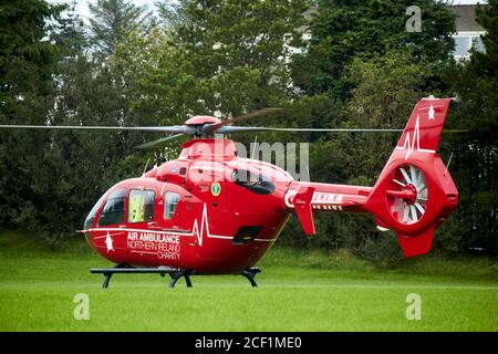 L'Air Ambulance dell'Irlanda del Nord è atterrato con rotori Girando su un campo di calcio scolastico in Newtownabbey Irlanda del Nord Ambulanza aerea del Regno Unito NOR Foto Stock