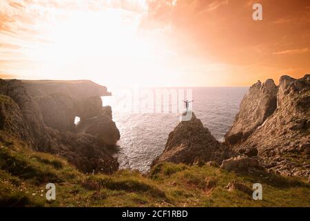 Donna che festeggia un tramonto sulla cima di un monte Viaggi, natura, escursioni in montagna con vista sull'oceano Foto Stock