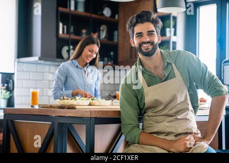 Ritratto di felice coppia giovane cucinare insieme nella cucina di casa. Foto Stock