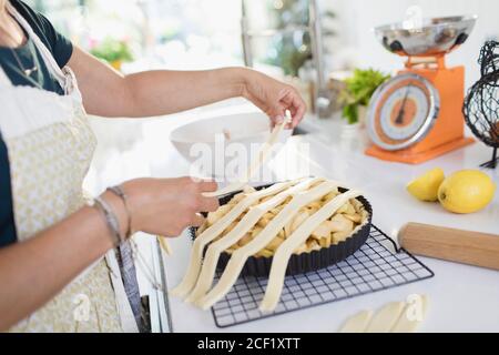 Donna che dispone crosta di reticolo su torta di mele Foto Stock