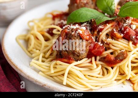 Spaghetti e polpette con salsa di pomodoro e parmigiano formaggio su un piatto da pranzo Foto Stock