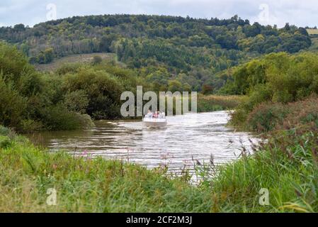 Persone che navigano in barca a motore sul fiume Arun vicino Amberley nel South Downs National Park, West Sussex, UK Foto Stock