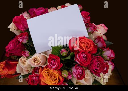 Bouquet di rose rosse, rosa e gialle con cartoncino vuoto. Modello per il compleanno, il matrimonio, il giorno della madre, il biglietto di San Valentino. Foto Stock