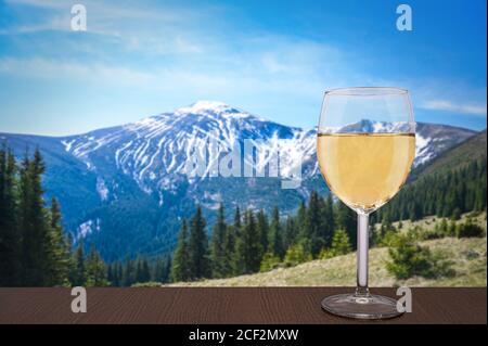 Bicchiere di vino bianco con vista sulle montagne in Romania. Bella vista di rocce, foresta e cielo blu in Carpazi Montagne. Paesaggio panoramico di montagna Foto Stock