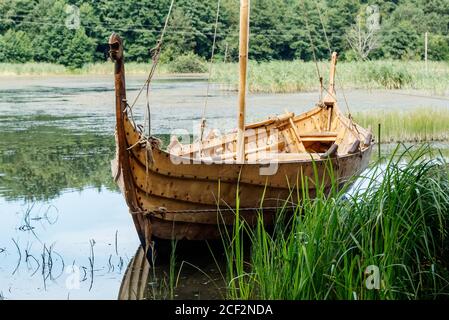 vecchia barca vichinga di legno vicino al lago in estate soleggiata giorno Foto Stock