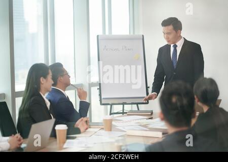 dirigente societario asiatico che presenta piani di azione in riunione d'affari in sala conferenze Foto Stock