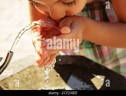 i bambini bevono acqua dalla primavera. Messa a fuoco selettiva . Foto Stock