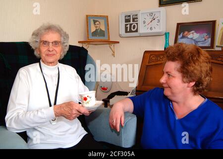 La donna anziana con demenza precoce vive da sola nella sua casa dell'associazione degli alloggi, aiutata da un programma che controlla le persone anziane che vivono indipendenti Foto Stock