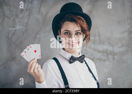 Primo piano ritratto di lei bella attraente bello affascinante contenuto allegra cheery ragazza con capelli ondulati che tiene in mano carte asso trattare Foto Stock