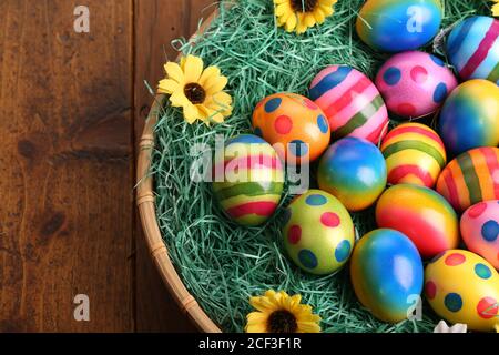 Foto ad alto angolo di uova di Pasqua splendidamente dipinte su un cestino decorato Foto Stock