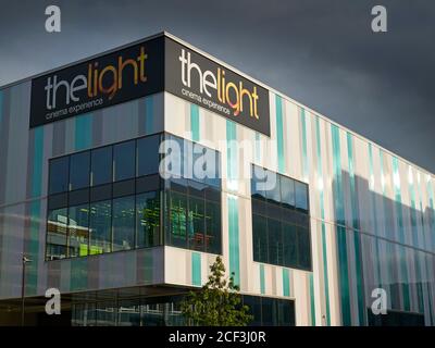 Luce del sole e ombre serali sul cinema Light, visto da Charter Row, Sheffield, con nuvole grigie dietro Foto Stock