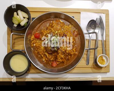 Riso di curry di pollo in Corea. Popolare cibo asiatico mescolato con lo stile Indiano, Giapponese e Coreano. Servito con zuppa di mais e cetrioli e rafano sottaceto. Foto Stock