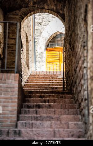 Assisi Umbria Italia vicolo di pietra vuoto con nessuno in piccolo borgo medievale storico architettura con scalini alla porta Foto Stock