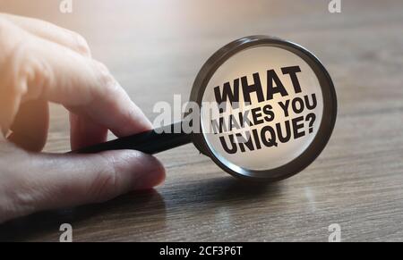 Che cosa vi rende domanda unica sotto la lente d'ingrandimento. Concetto di business professionale Foto Stock