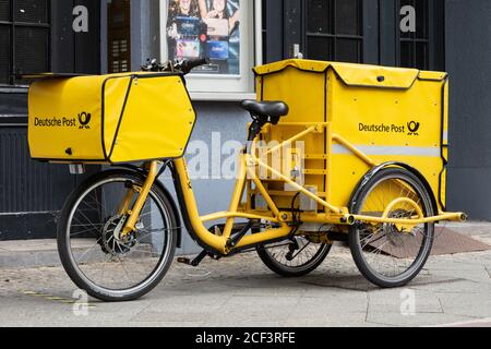 Bicicletta di un postino dell'Ufficio postale tedesco in piedi di fronte ad un ingresso Foto Stock