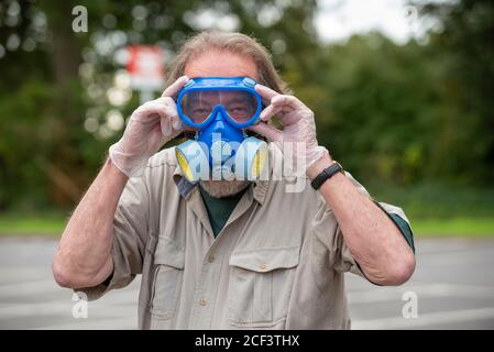 Hampshire, Inghilterra, Regno Unito. 2020. Ritratto di un uomo che indossa guanti, una maschera con filtro e occhiali durante l'epidemia di Covid-19 nel Regno Unito. Foto Stock