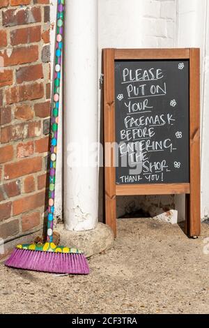 Avviso all'esterno di un negozio chiedendo ai clienti di indossare il facemask prima di entrare durante la pandemia del 2020 Coronavirus covid-19, Regno Unito Foto Stock