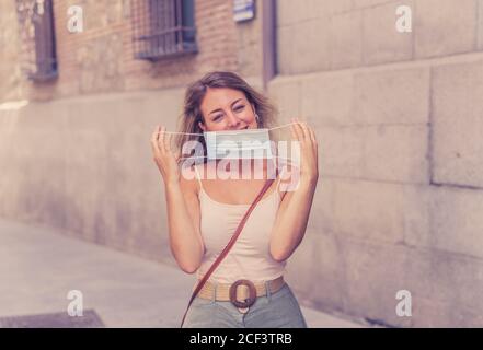 Giovane donna che indossa una maschera protettiva all'aperto nella strada della città. Immagine positiva di Nuova vita normale dopo COVID-19 e protocolli sanitari per evitare infec Foto Stock