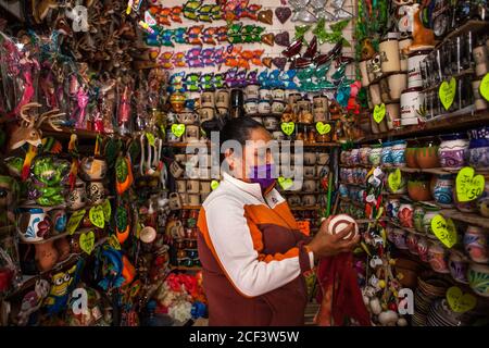 Real De Catorce, Messico. 13 giugno 2020. Una donna che lavora in negozio indossando una maschera facciale come precauzione.anche se il numero di visitatori non è paragonabile a quelli prima della pandemia di Covid-19, Real de Catorce in San Luis Potosí Stato ha lentamente iniziato a riavviare l'economia, soprattutto dove il turismo è la principale fonte di reddito. Credit: SOPA Images Limited/Alamy Live News Foto Stock