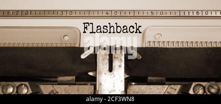 Parola 'flashback' digitata su una macchina da scrivere retrò. Effetto Seppia. Concetto aziendale. Foto Stock