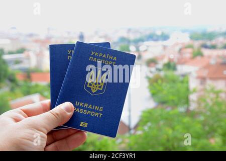 Nuovo passaporto biometrico blu ucraino con chip d'identificazione sullo sfondo della città. Foto Stock