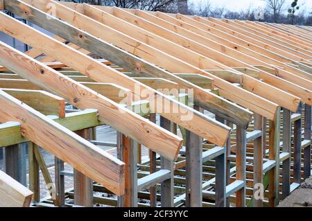 Installazione di travi in legno in costruzione il sistema di capriate del tetto della casa. Foto Stock