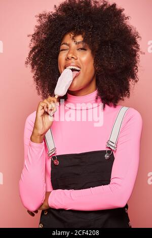 Donna divertente con gelato sul bastone guardando la macchina fotografica Foto Stock