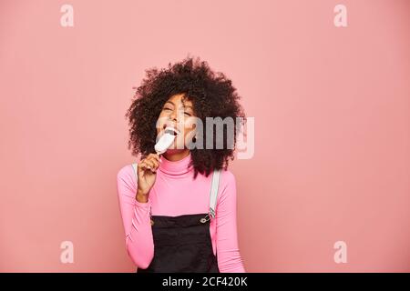 Donna divertente con gelato sul bastone guardando la macchina fotografica Foto Stock