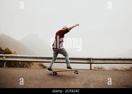 Skateboarder trendy che fa trucco in natura Foto Stock