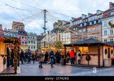 Varsavia, Polonia - 25 dicembre 2019: Piazza del mercato della città vecchia rynek a Warszawa di notte con decorazione di illuminazione di Natale e persone pattinaggio su ghiaccio ri Foto Stock
