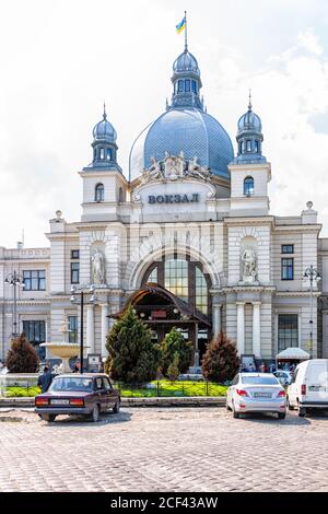 Lviv, Ucraina - 1 agosto 2018: Facciata esterna architettura della stazione ferroviaria di Lvov con segno Vokzal e cupola storica in ucraino ci Foto Stock